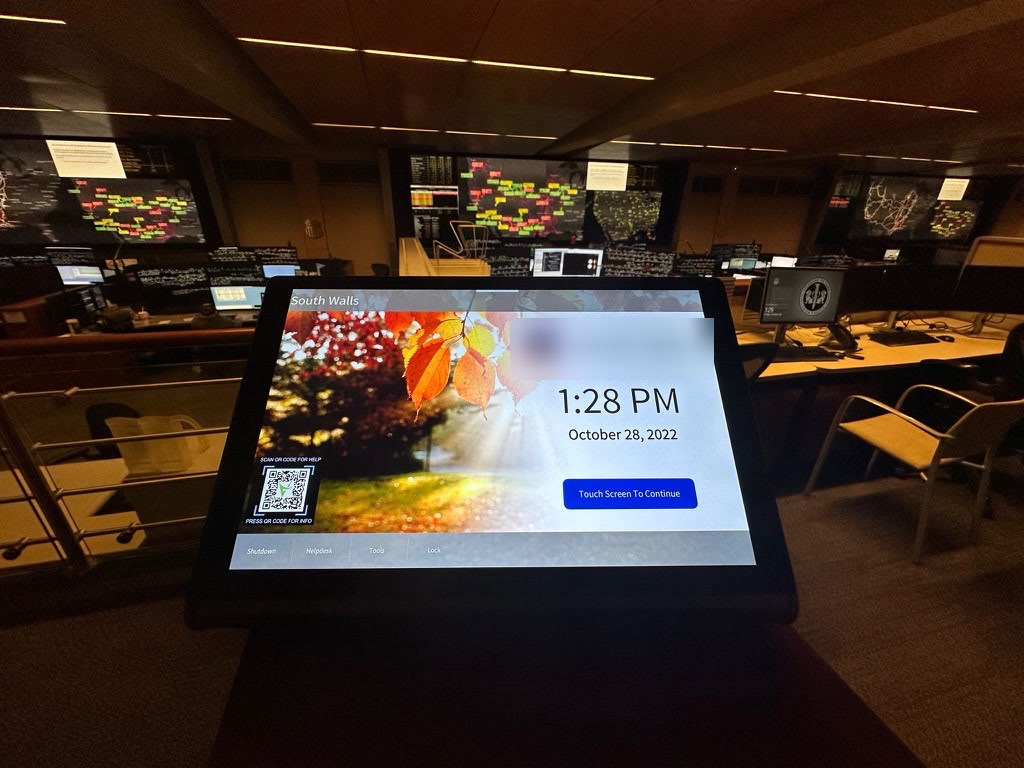 Commissioned control room with operator displays and an identifying touch-panel mark blurred for privacy
