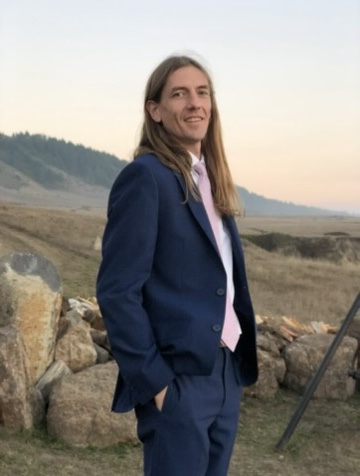 Trevor Hain, founder of EchoWerks, wearing a navy suit outdoors